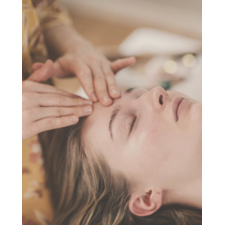close-up of a woman's face receiving a rejuvenating facial marma therapy and energy healing